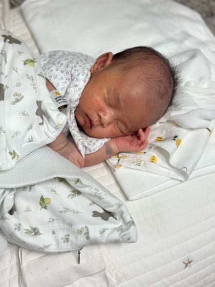 エアコンをつけた涼しい部屋で、薄い夏の肌着を着てぐっすり眠る赤ちゃん