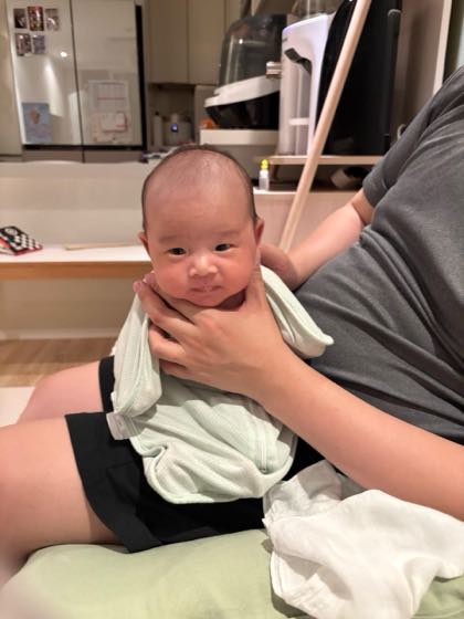 涼しい室内で親の腕に抱かれて安心している赤ちゃん