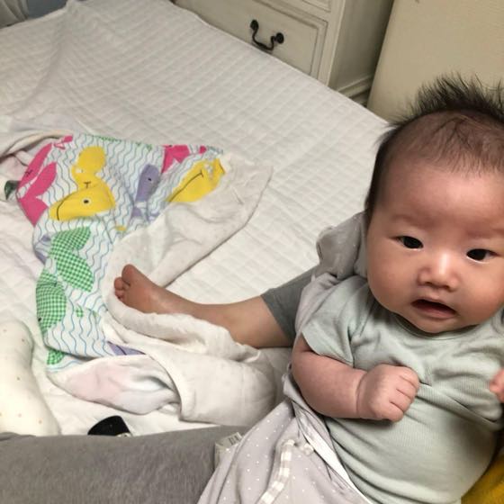 A baby propped on the bed looking at the camera on an ordinary day — the kind of candid daily shot that pairs nicely with today's one line