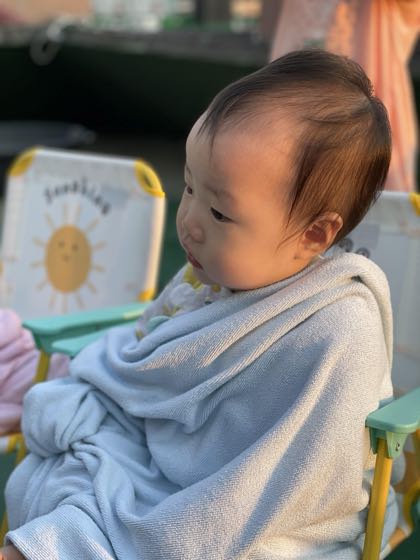 목욕을 마치고 부드러운 수건에 감싸여 앉아 있는 아기