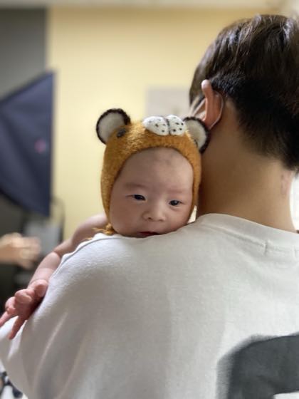 親の腕に抱かれて様子を見てもらう赤ちゃん