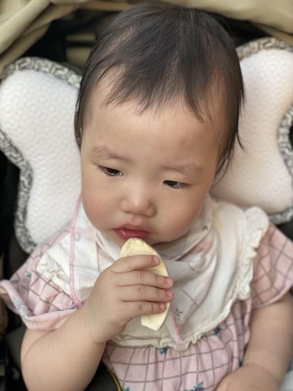 쌀과자를 손에 쥐고 입에 가져가는 아기의 모습