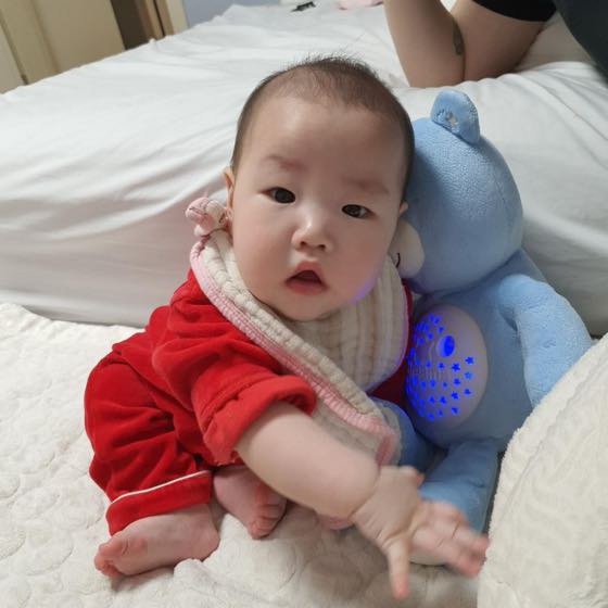 낮잠 시간에 잠자리에서 수면등을 곁에 두고 잠들지 않은 채 눈을 뜨고 있는 아기