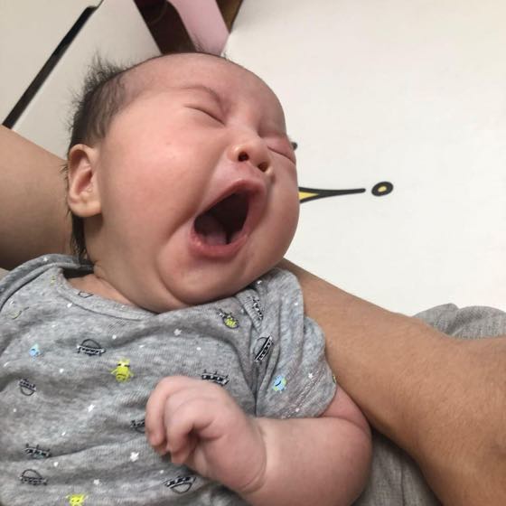 과피로로 보채는 아기를 안아 달래는 부모